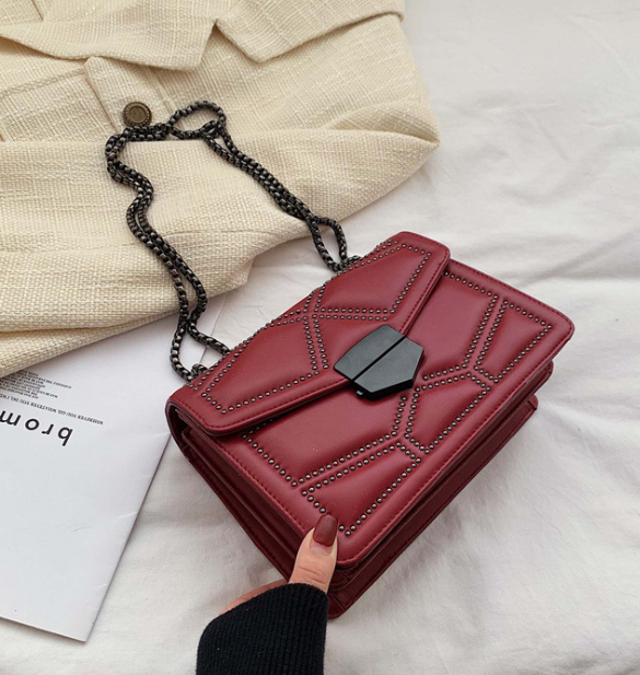 Kompaktowa damska torebka crossbody z ćwiekami i łańcuszkiem
